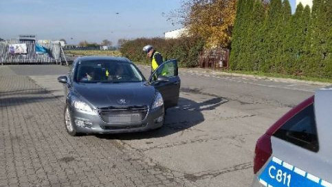 policjant kontroluje oświetlenie pojazdu