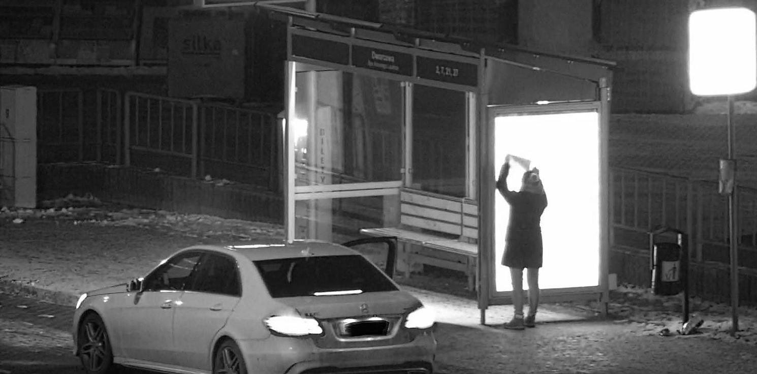 Inowrocław - Naklejała ulotki na nowych wiatach przystankowych