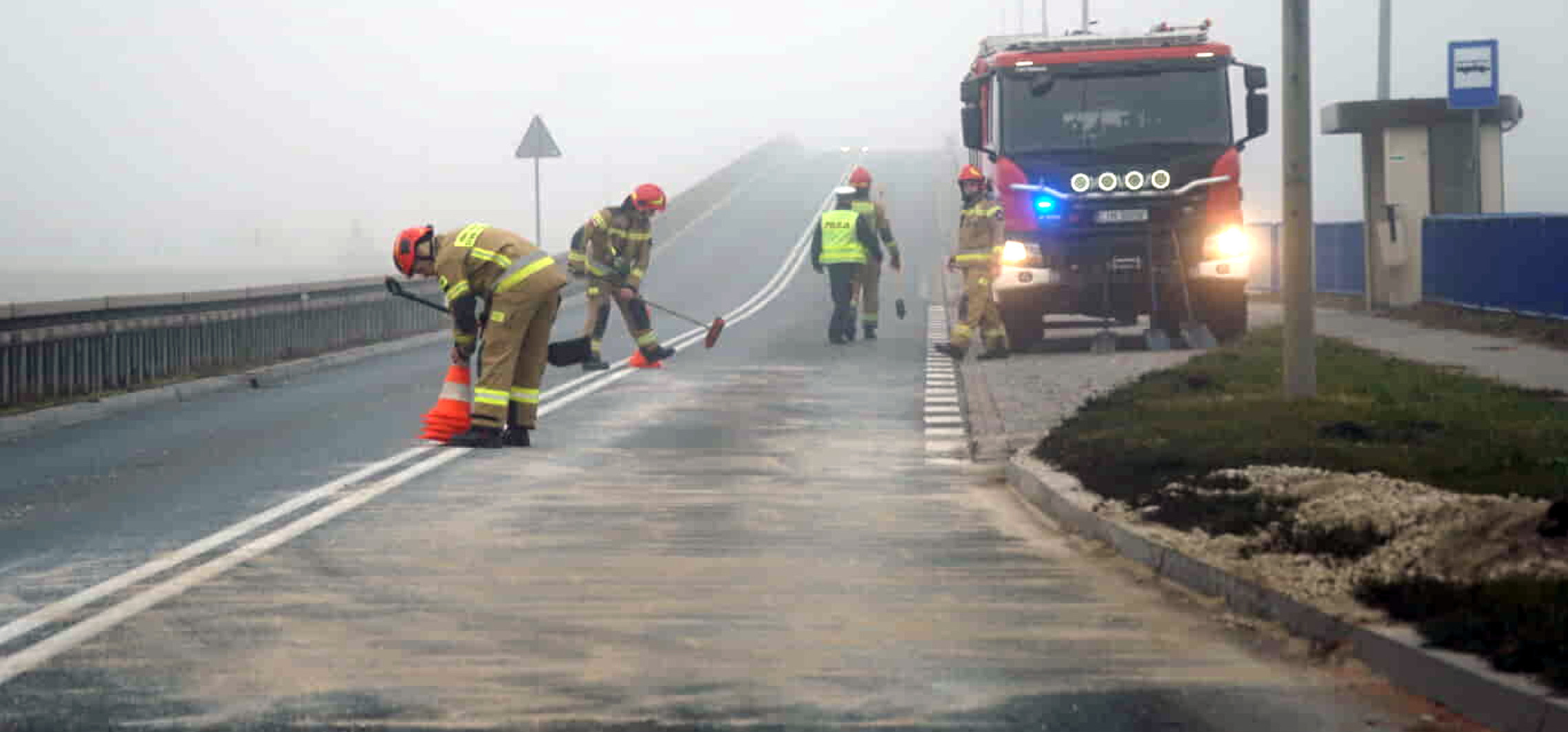 Biały kamień rozsypany na drodze. Strażacy w akcji